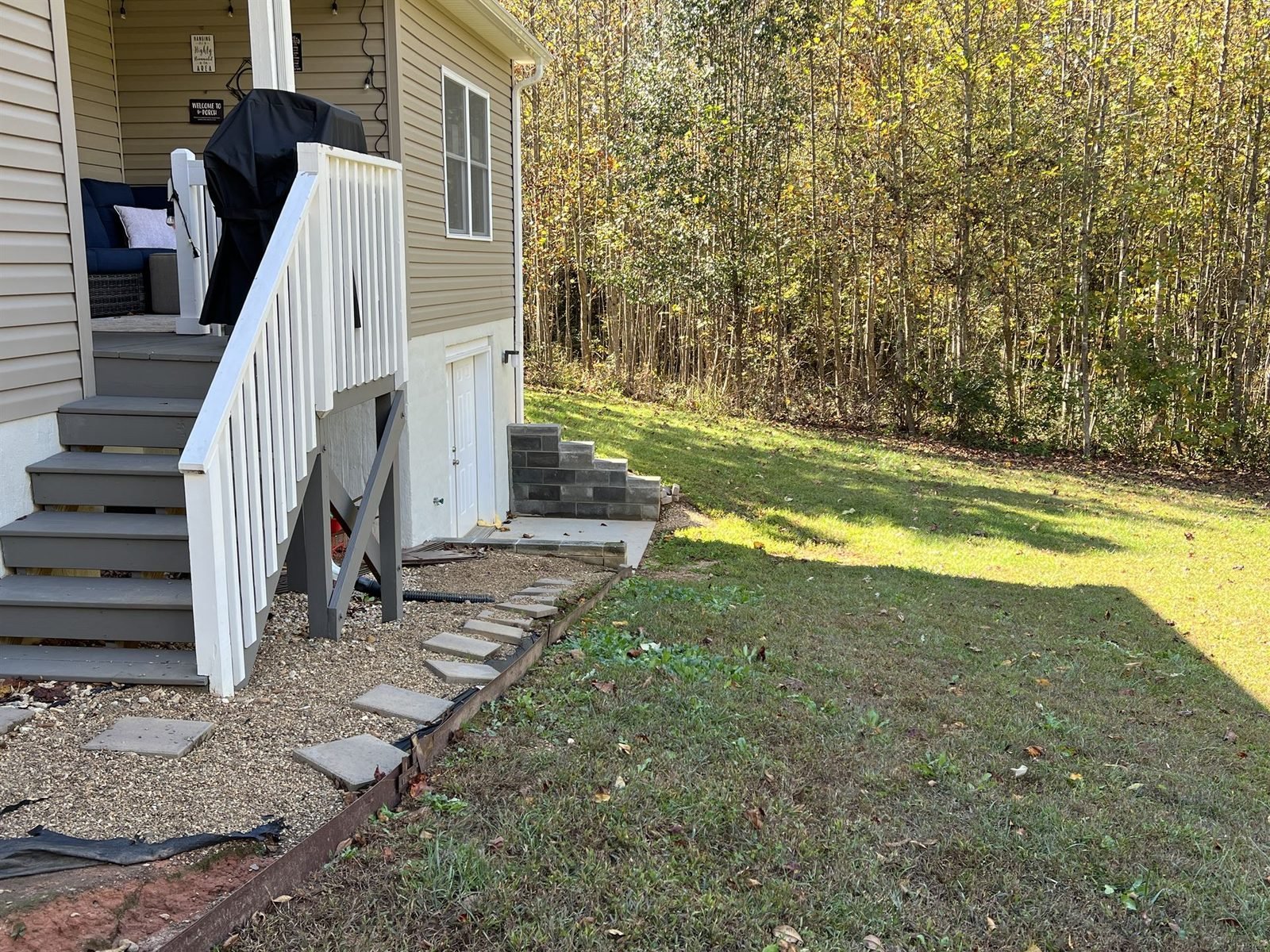 Bare gravel backyard before paver patio and retaining wall installation Western NC